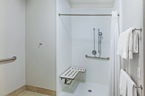 A shower area with a grab bar, a showerhead, and a towel rack. - Holiday Inn Express Hotel & Suites Dallas Lewisville by IHG (Lewisville)