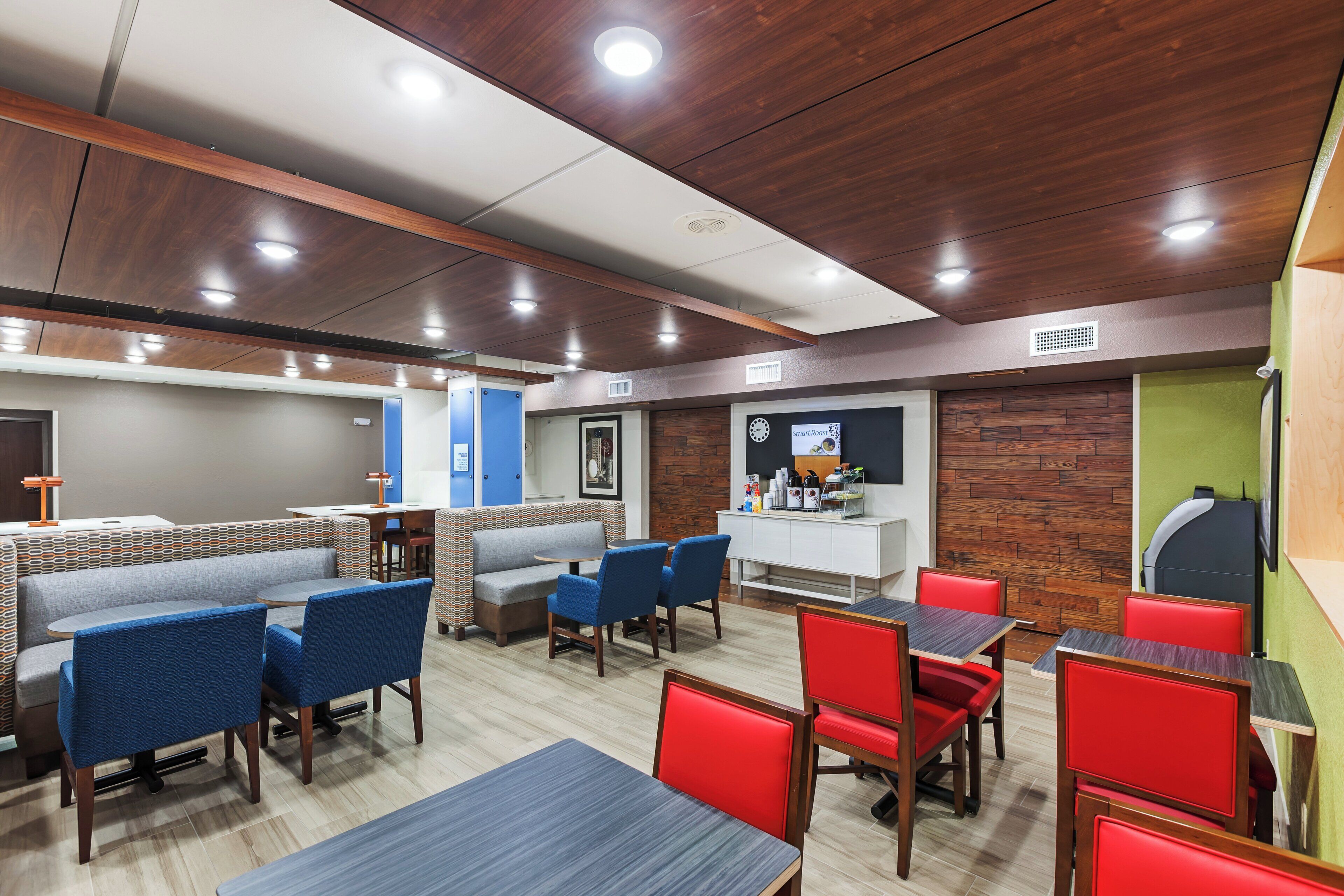Un interior de restaurante moderno con cabinas, mesas altas y una barra.