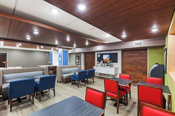 A modern restaurant interior with booths, high tables, and a counter area.