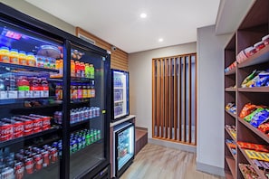 A vending area with various drinks and snacks, including soda cans and bottled water.