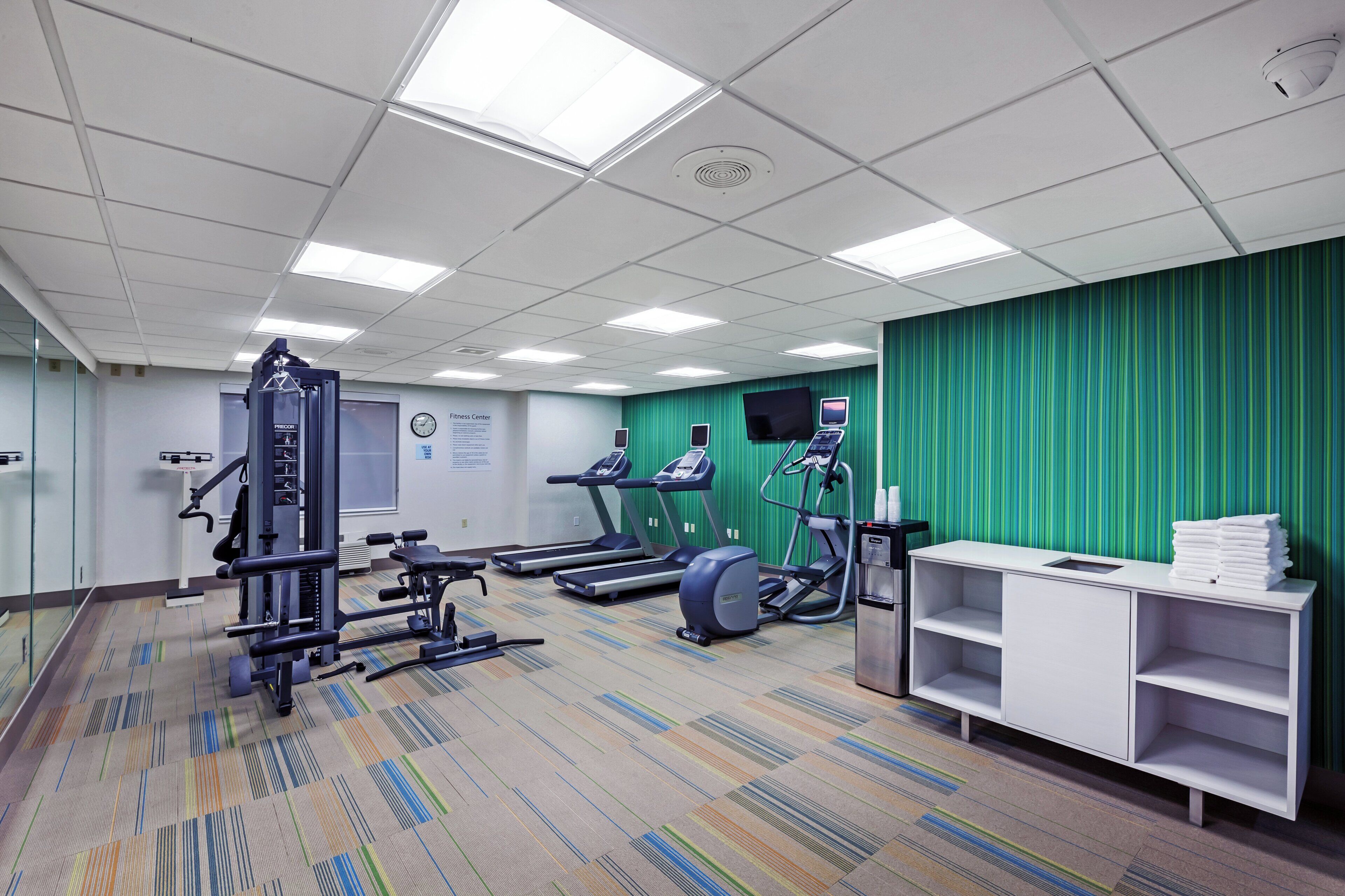 A fitness center with treadmills, elliptical machines, and weightlifting equipment.