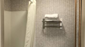 A bathroom with a shower, toilet, and towel rack.