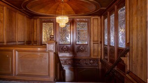 A grand wooden staircase with intricate carvings, a chandelier, and stained glass windows. - Best Western Hotel Plaza Matamoros (Matamoros)