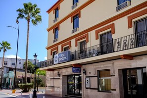 Un hotel con cartel de Best Western, un restaurante y un balcón con barandillas negras.