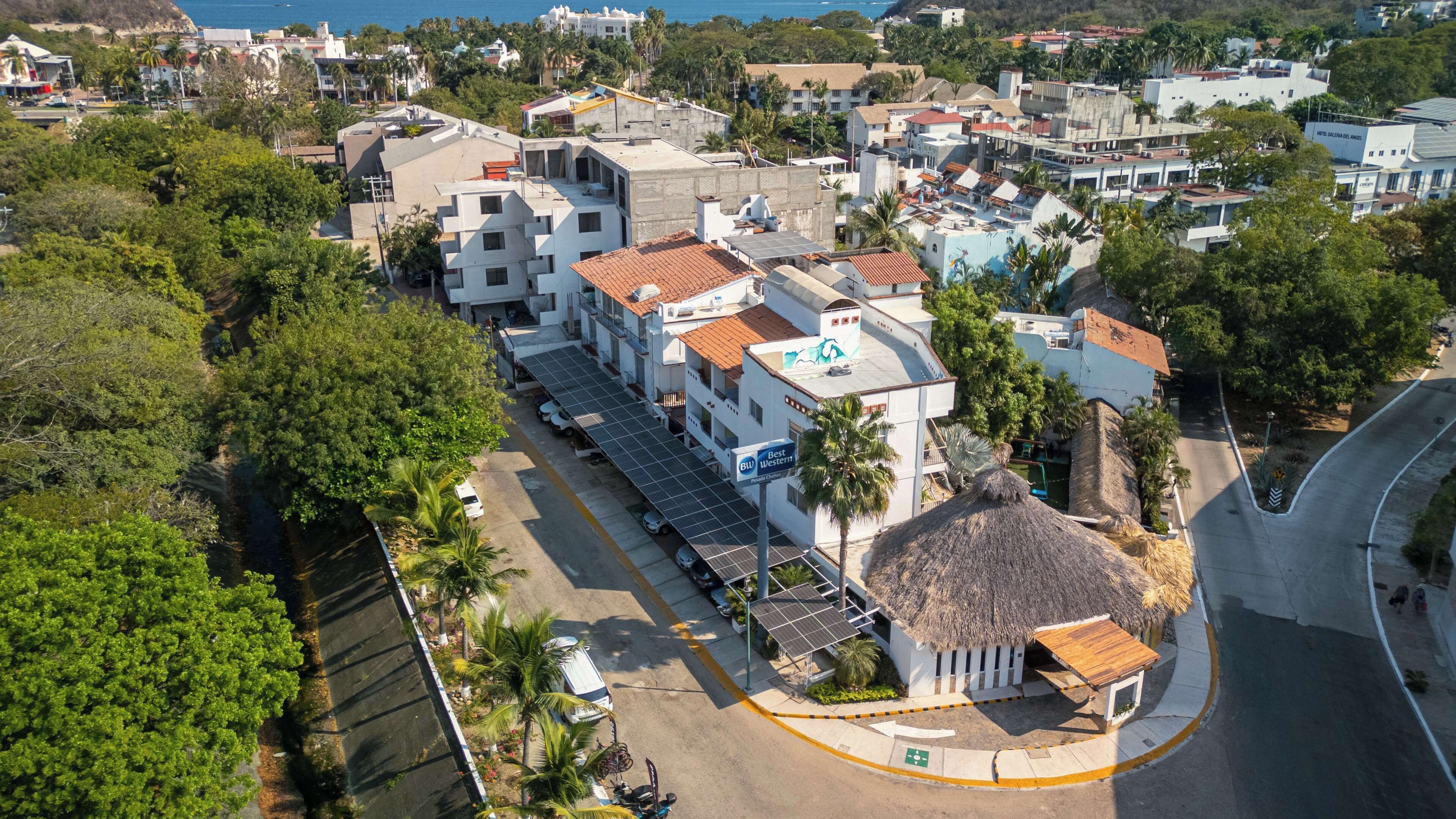 Vista aérea de un pueblo costero con edificios, una carretera y una playa.