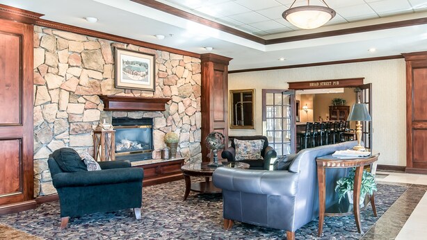 A spacious lobby with a stone fireplace, leather sofas, and a billiards table. - The Marx Hotel (Oneonta)