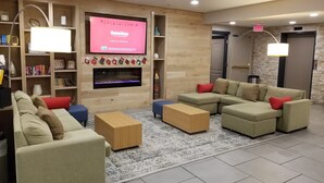 A modern living room with a flat-screen TV, a fireplace, and a cozy seating area.