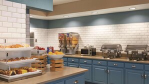 A modern kitchen with a breakfast bar, a coffee station, and a microwave.