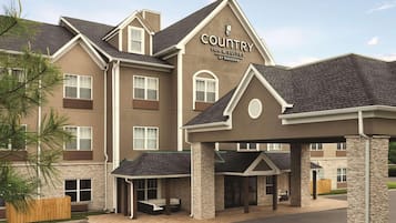 Stylish entrance with a covered area and stone pillars.