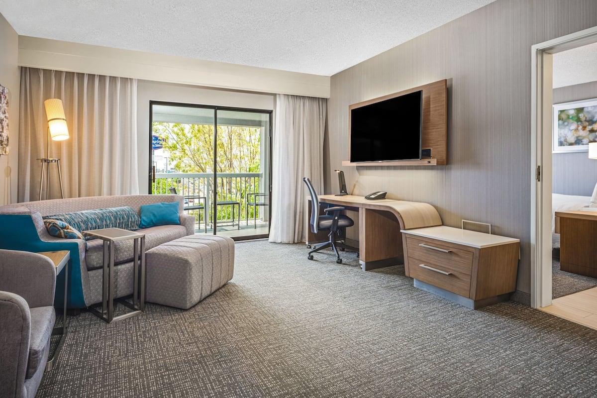Habitación de hotel moderna con sofá, escritorio y televisión.