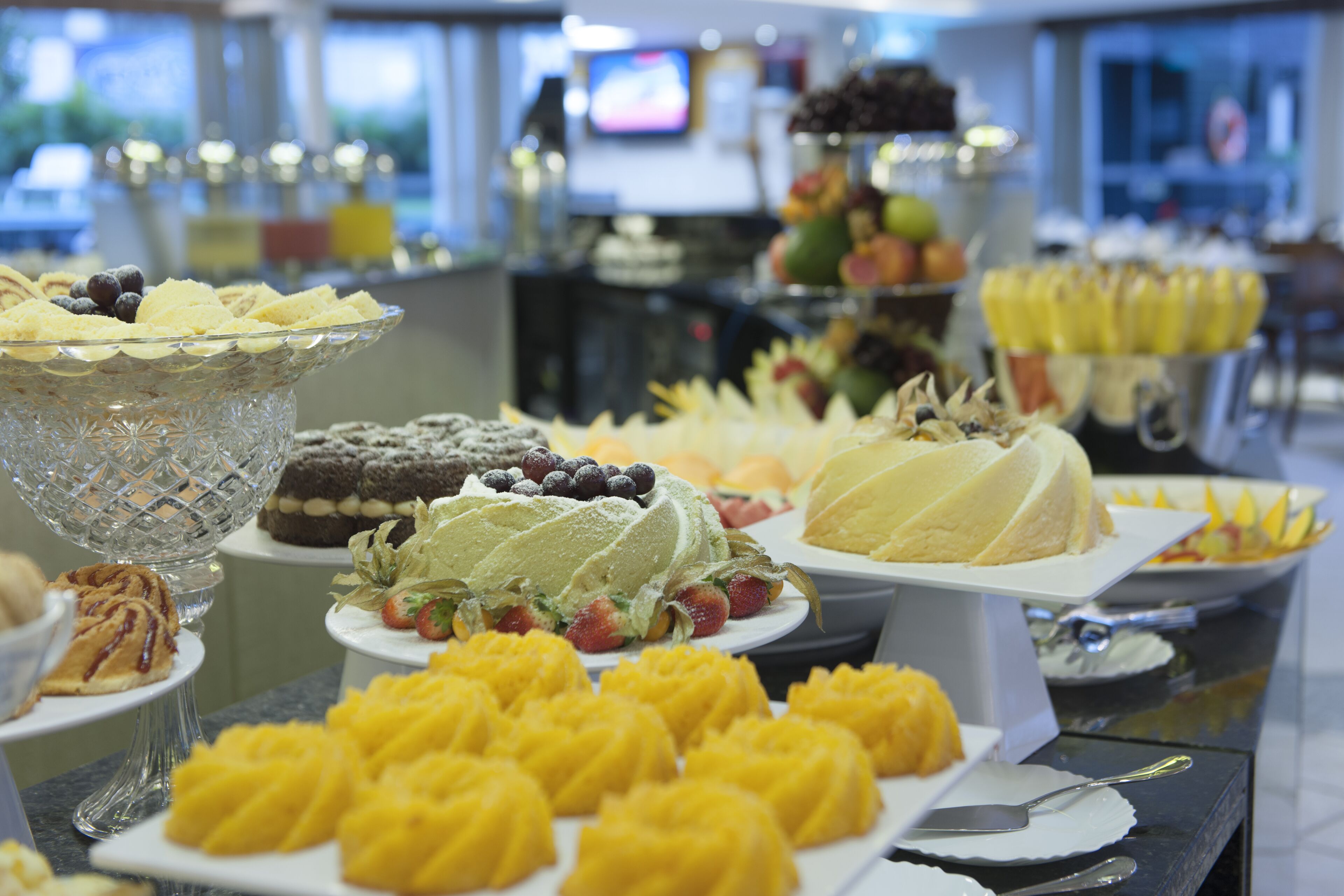 A buffet with various desserts and fruits.
