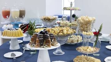 A buffet table with various desserts and beverages.