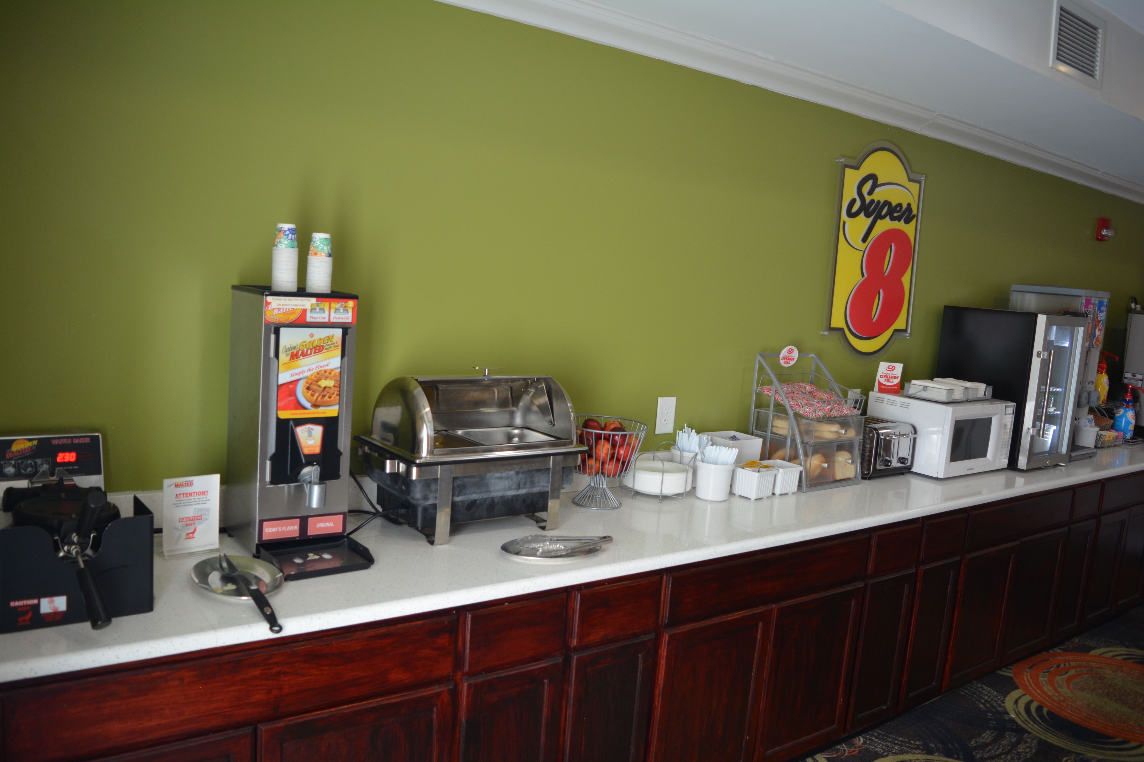 A buffet counter with a coffee machine, a microwave, and a refrigerator.