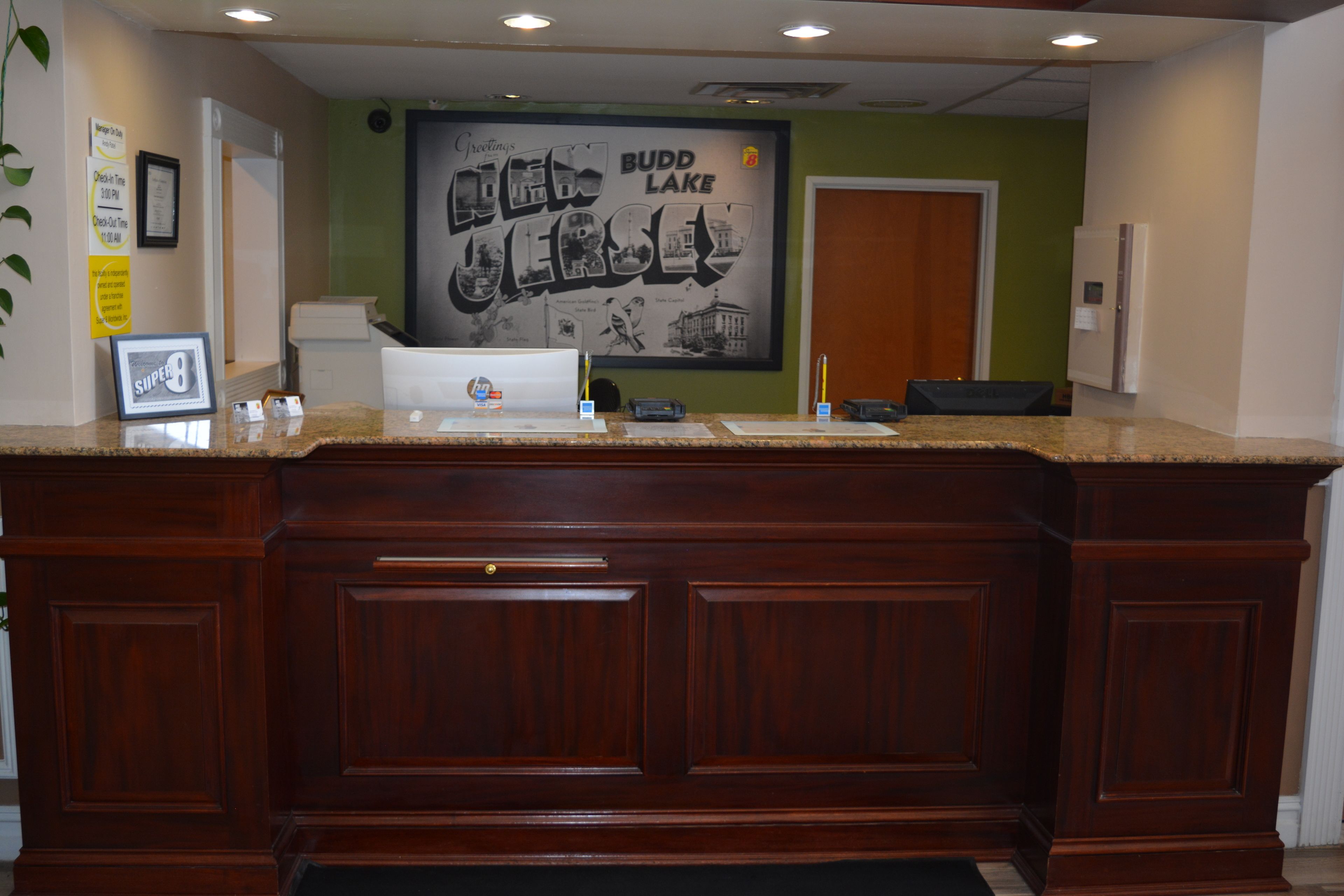 A reception desk with a framed sign, a bulletin board, and a framed picture.