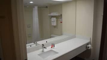 A bathroom with a white sink, mirror, and towel rack.