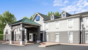 Un hôtel doté d’une entrée abritée, d’une enseigne indiquant « Baymont Inn & Suites » et d’un panneau de signalisation pour le stationnement.