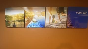 A wall with four framed pictures depicting outdoor activities.