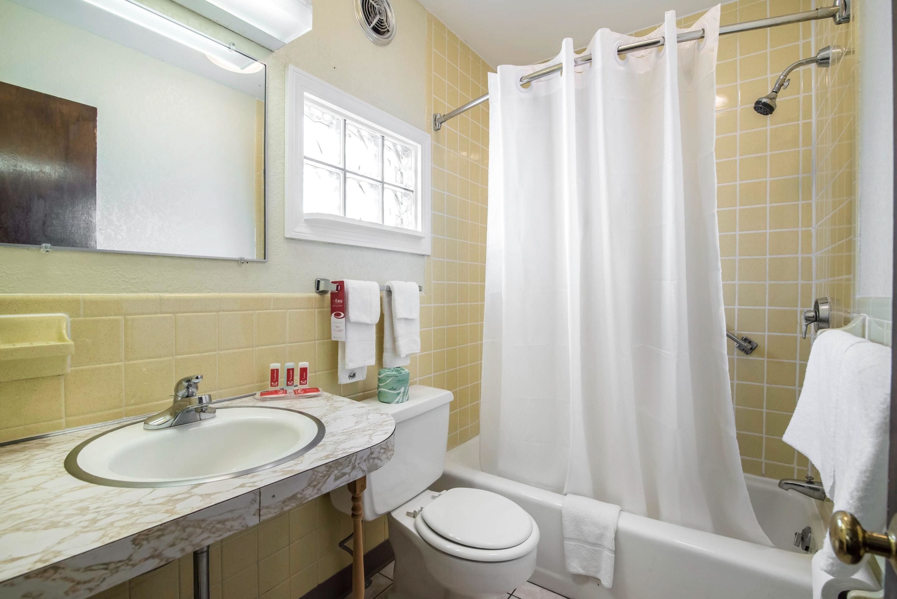 Een badkamer met een wastafel, toilet en bad.