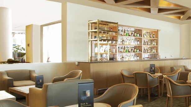 A bar area with multiple seating options and a well-stocked bar counter. - Fiesta Inn Express Hermosillo (Hermosillo)