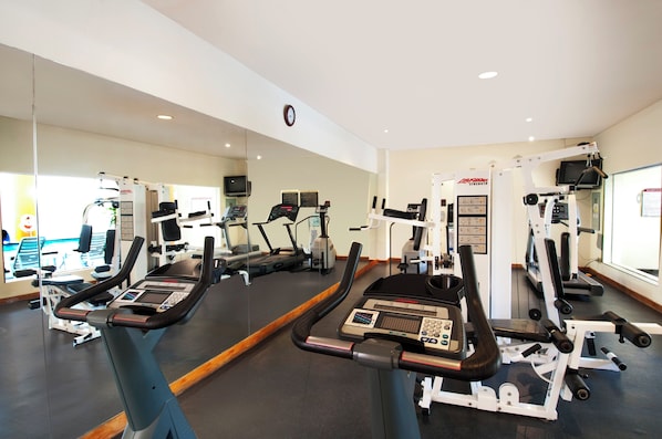 A gym with treadmills, elliptical machines, and weight machines.