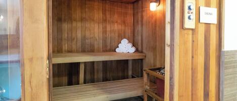 Una sauna de madera con bancos y un panel de control.