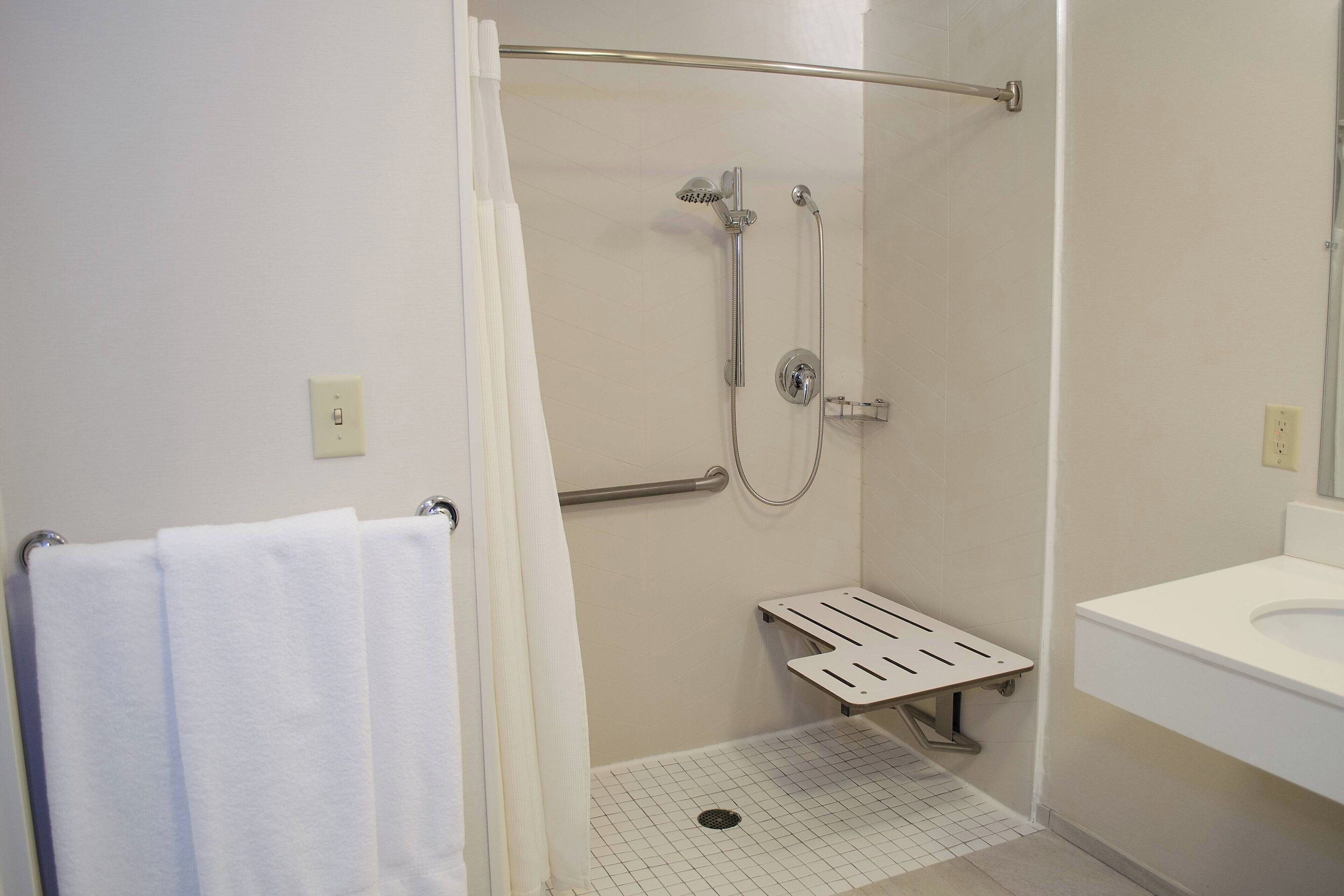 A bathroom with a shower, a toilet, and a sink.