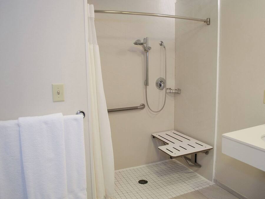 A bathroom with a shower, a toilet, and a sink.