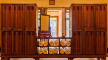 A traditional Japanese room with sliding doors, a wooden bench, and neatly rolled towels.