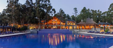 Una piscina techada, una piscina al aire libre de temporada, sombrillas