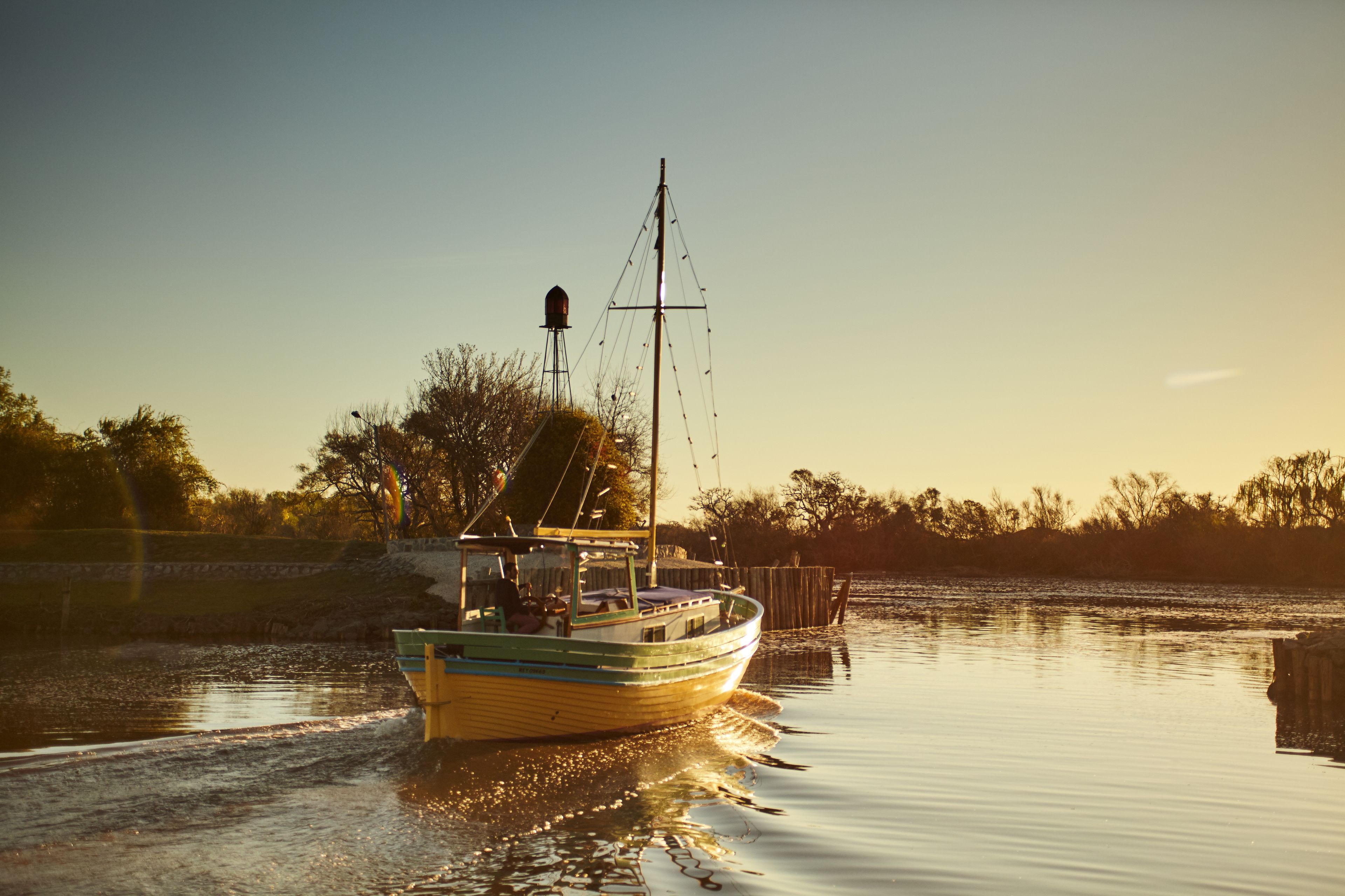 Een boot op rustig water, met een steiger op de achtergrond.