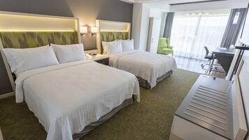 Quarto de hotel com duas camas, uma escrivaninha e uma cadeira.