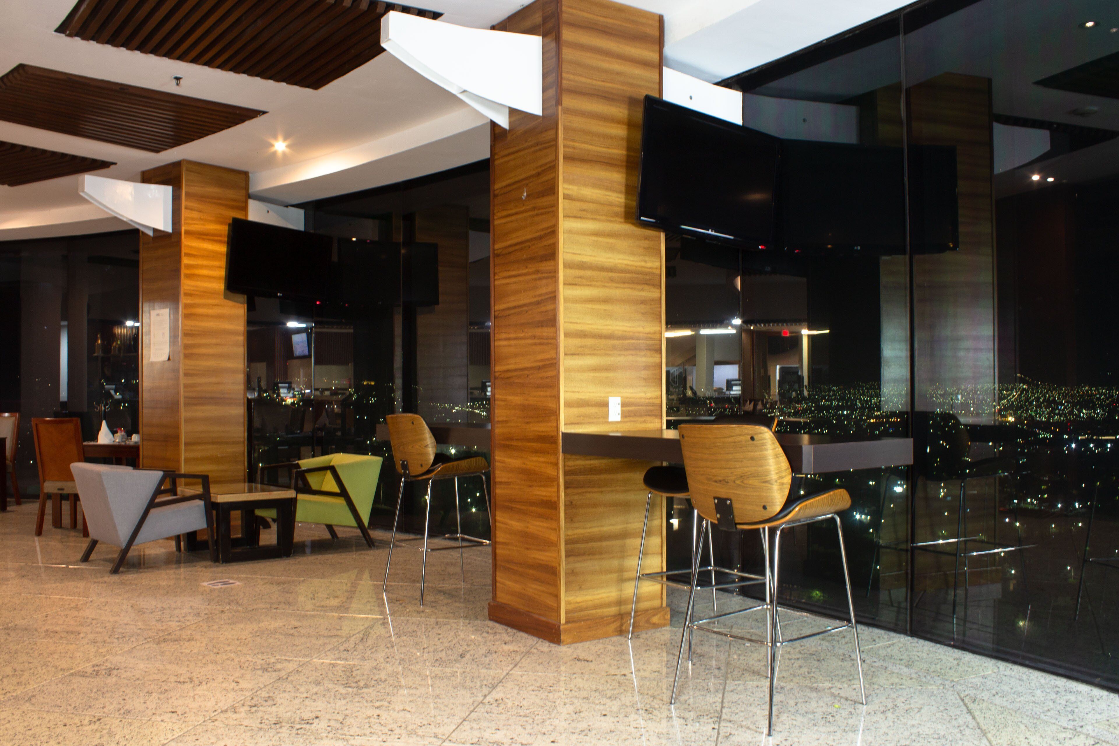 Un interior moderno con vistas a la ciudad, detalles de madera y mobiliario contemporáneo.
