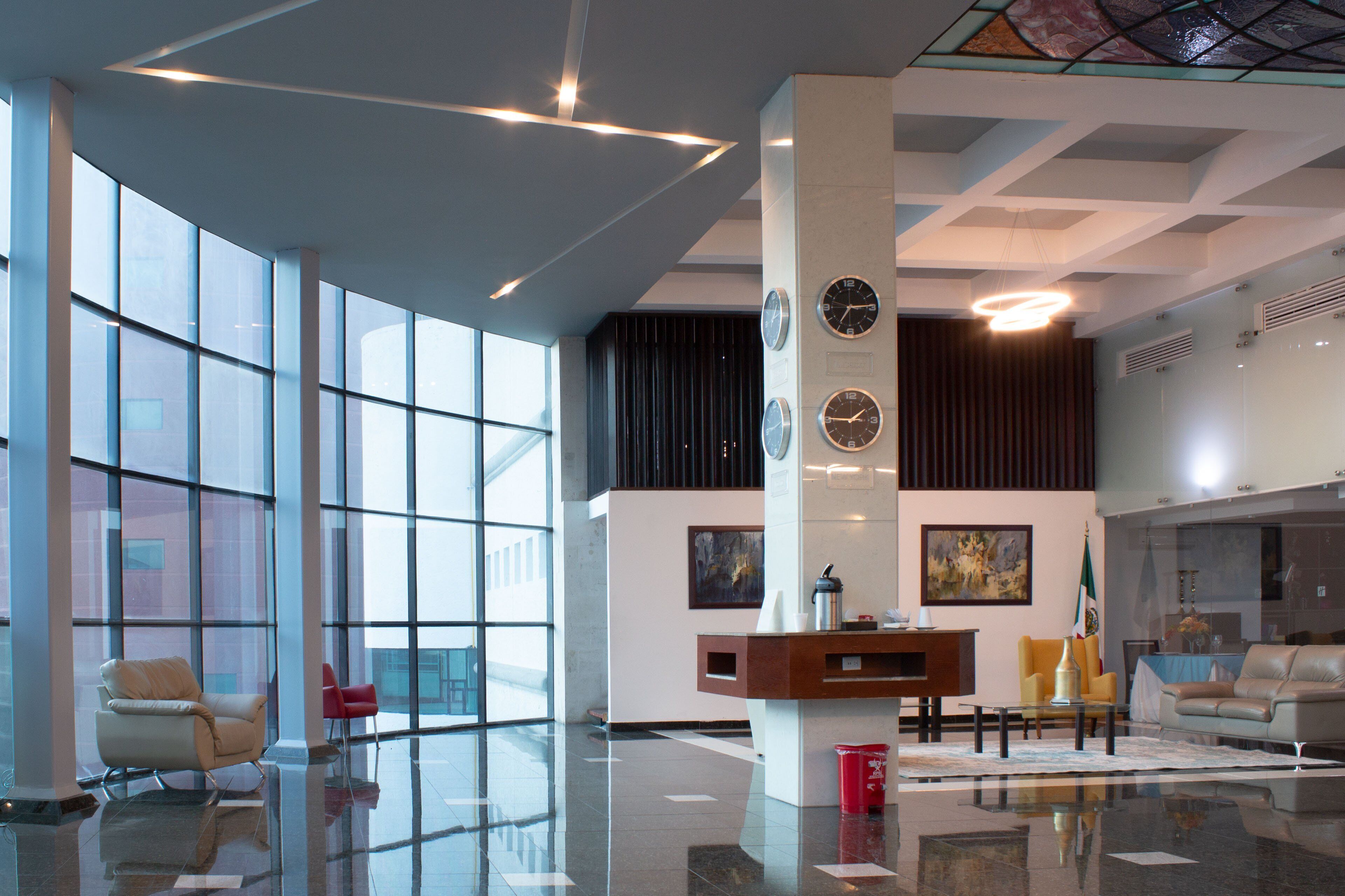 A spacious lobby with large windows, a reception desk, and seating areas.
