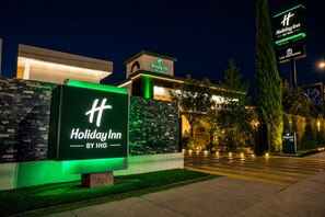 A Holiday Inn sign with a modern building in the background. - Holiday Inn Durango by IHG (Durango)