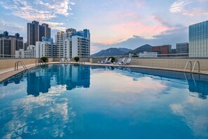 Una piscina al aire libre, tumbonas