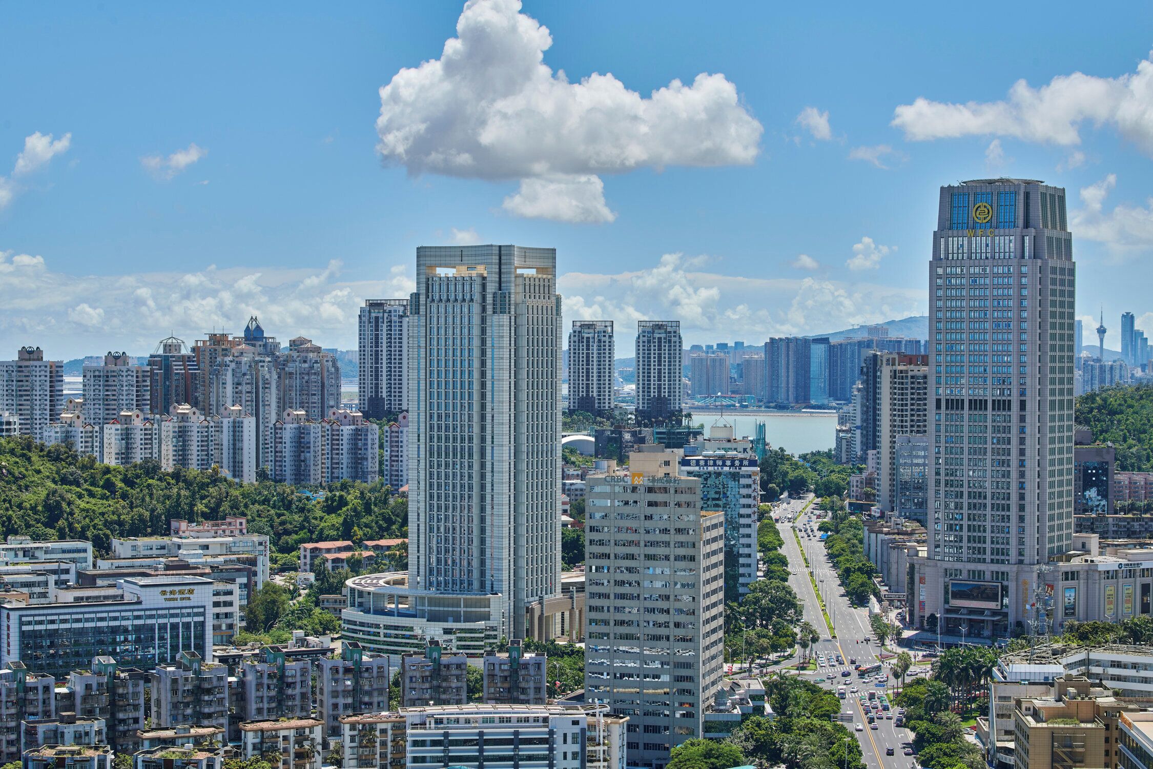 A cityscape with high-rise buildings, a river, and a clear sky.