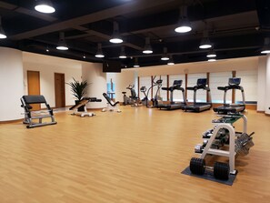 A spacious gym with various exercise equipment, including treadmills, elliptical machines, and weight benches. - Crowne Plaza Zhuhai City Center by IHG (Zhuhai)