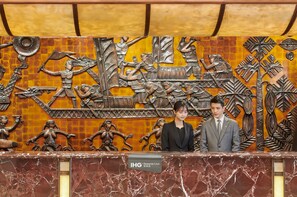 A reception desk with a metal sculpture of warriors and a sign reading "IHG Rewards Club". - Crowne Plaza Zhuhai City Center by IHG (Zhuhai)
