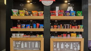 Een snackvitrine met diverse merken zoals Lay's, Doritos en Takis.