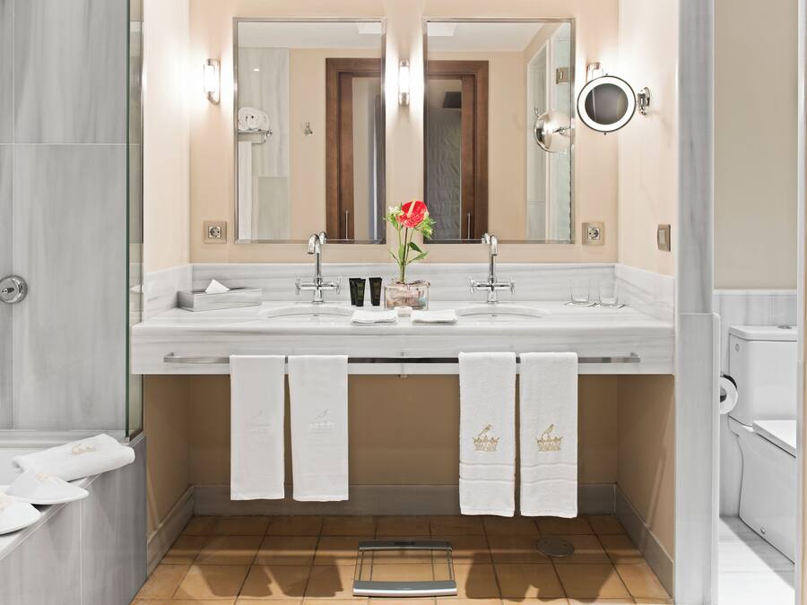A modern bathroom with a dual sink vanity, a large mirror, and a glass shower enclosure.