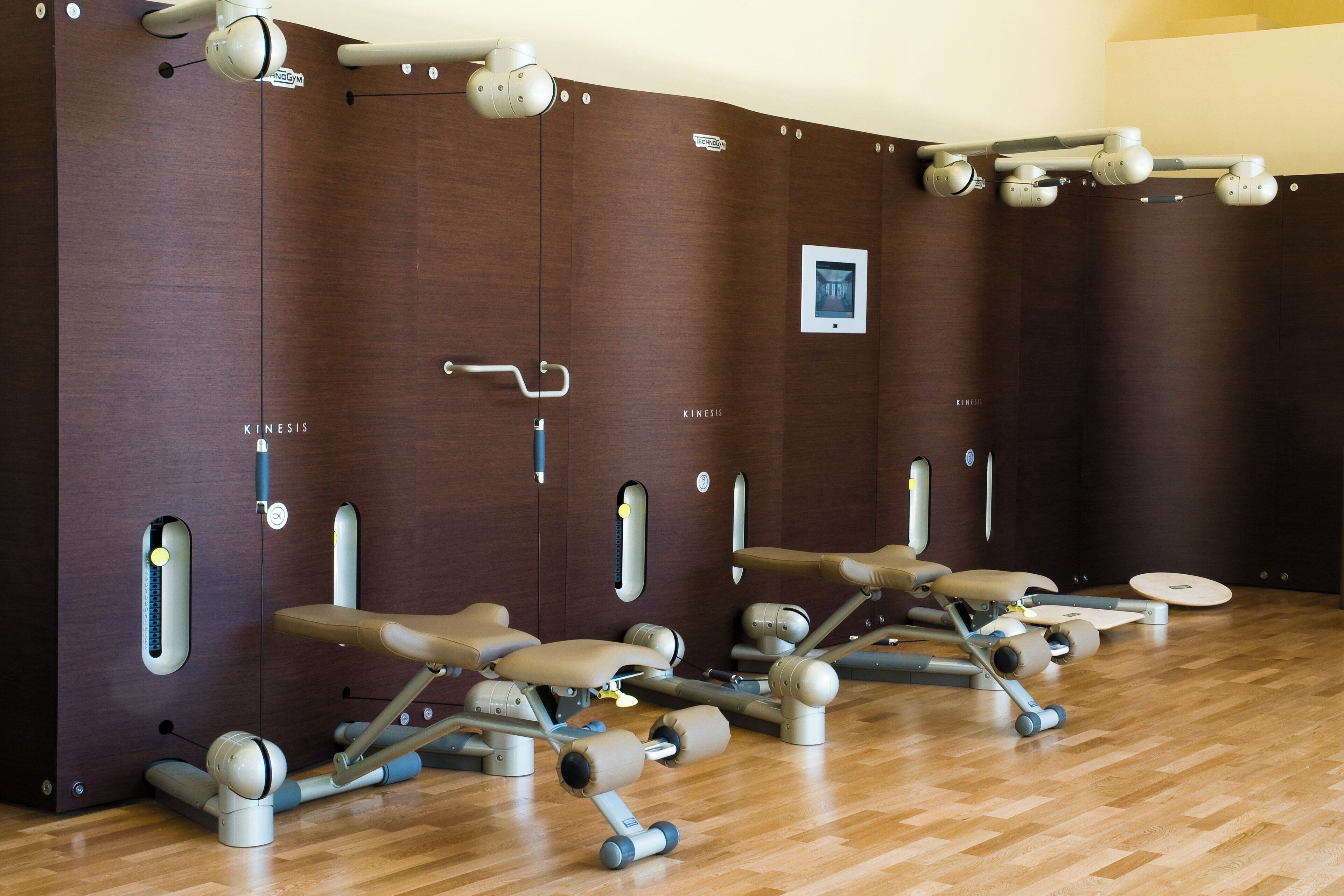 Un gimnasio con equipo de ejercicio y suelo de madera.