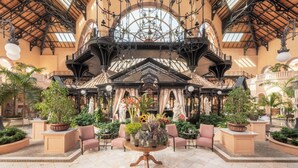 A spacious lobby with a high ceiling, ornate ironwork, and a central chandelier. - Bahia del Duque (Adeje)