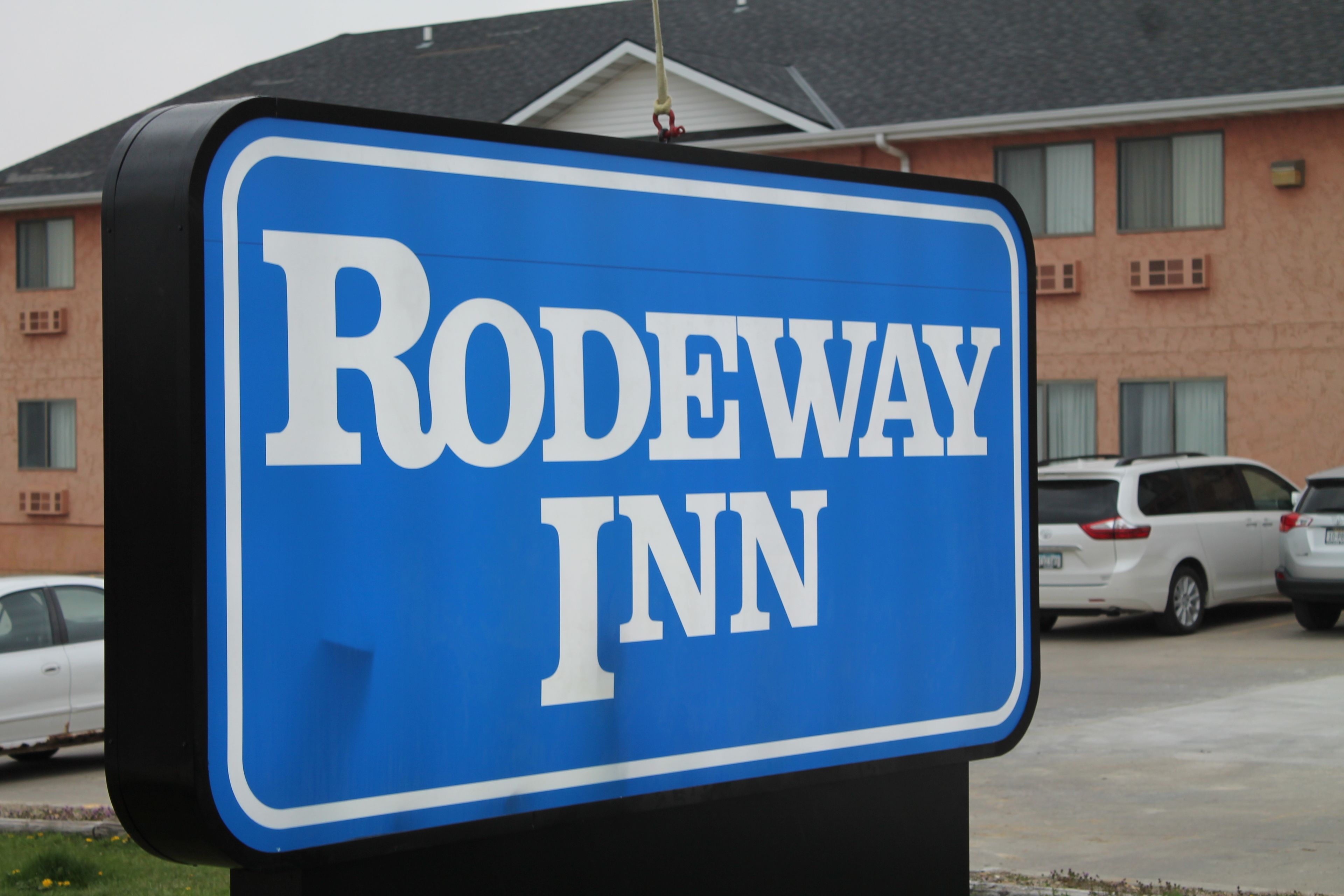 A blue sign with "RODEWAY INN" written on it.