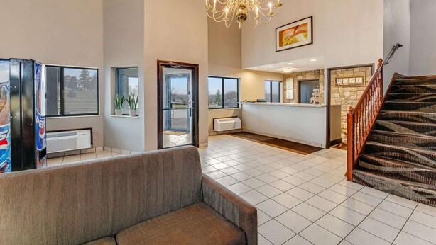 A spacious lobby with a reception desk, a staircase, and a chandelier. - Rodeway Inn Red Oak (Red Oak)