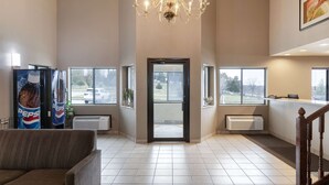 A spacious lobby with a chandelier, large windows, and a Pepsi refrigerator. - Rodeway Inn Red Oak (Red Oak)