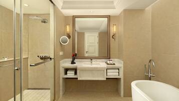 Une salle de bain moderne avec une douche à l’italienne, un lavabo avec un meuble-vasque et une baignoire îlot.