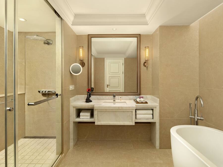 Une salle de bain moderne avec une douche à l’italienne, un lavabo avec un meuble-vasque et une baignoire îlot.