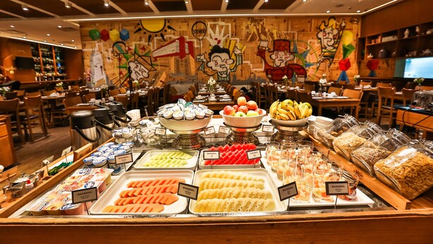 A buffet with various food options and a mural on the wall. - Radisson Blu São Paulo (São Paulo)