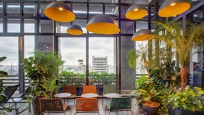 A modern indoor space with large windows, wicker furniture, and potted plants. - Radisson Blu São Paulo (São Paulo)