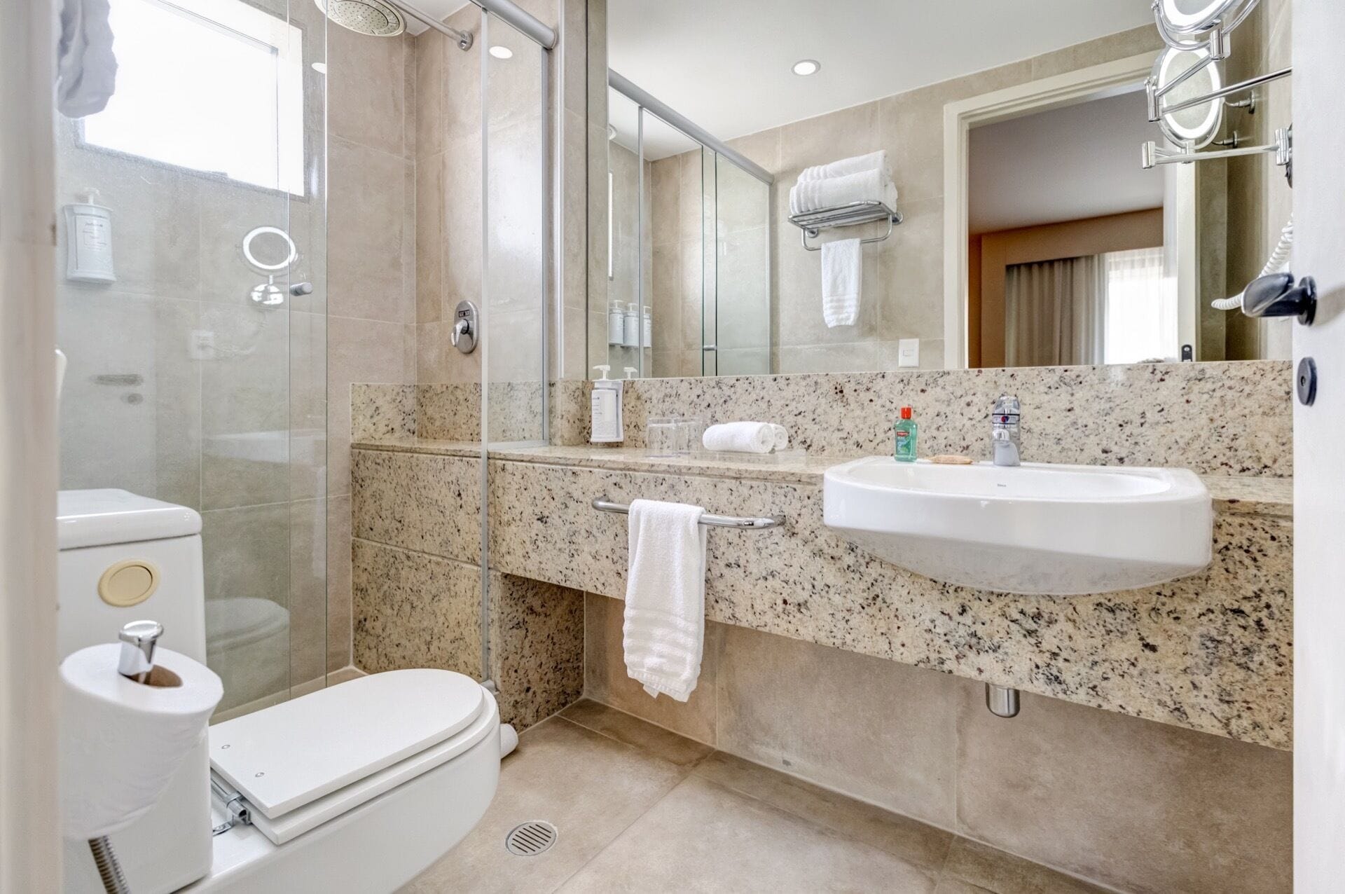 A modern bathroom with a toilet, sink, and shower.